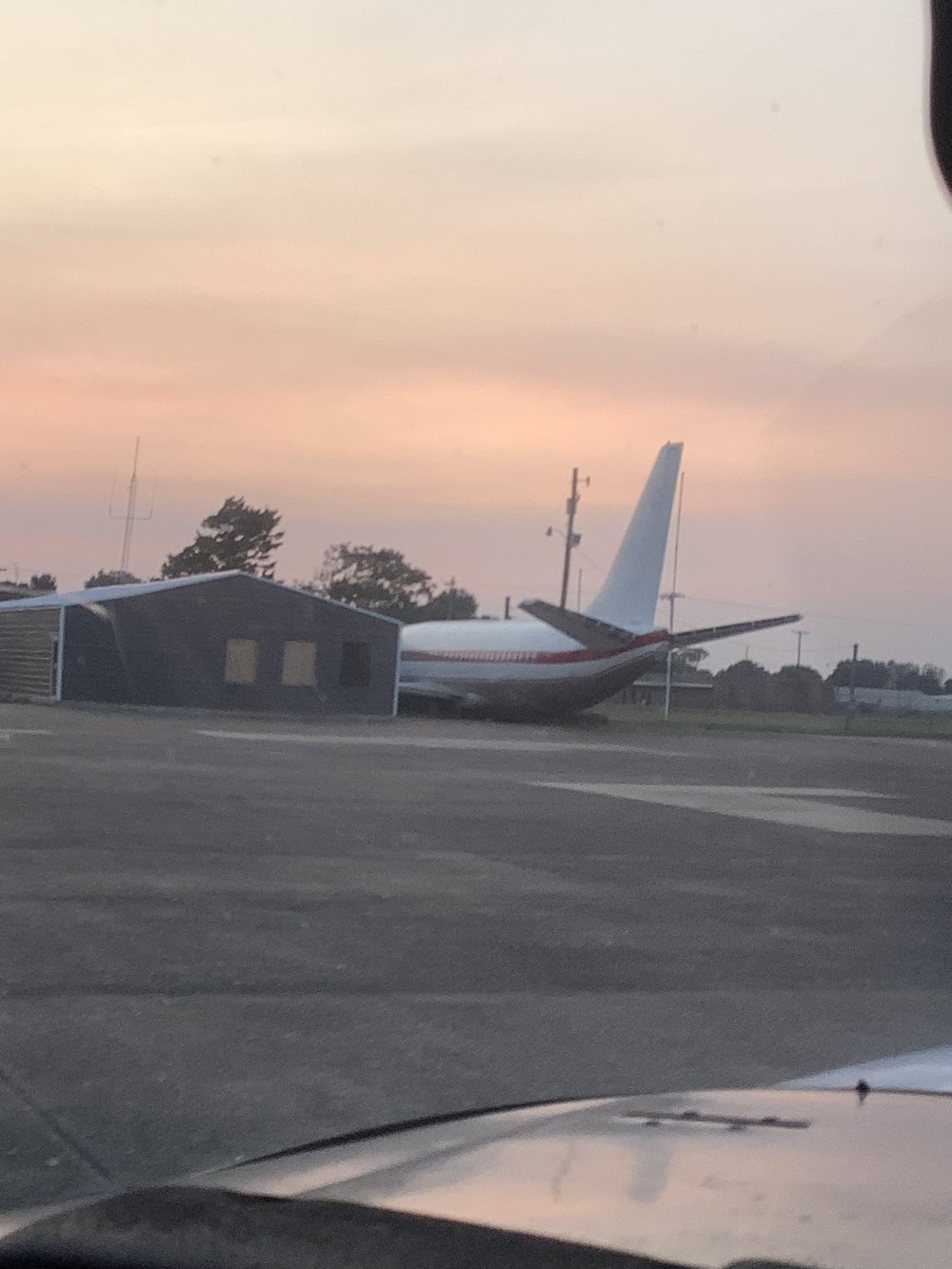 Aircraft silhouetted at dusk on the Walnut Ridge ramp the evening before the final flight